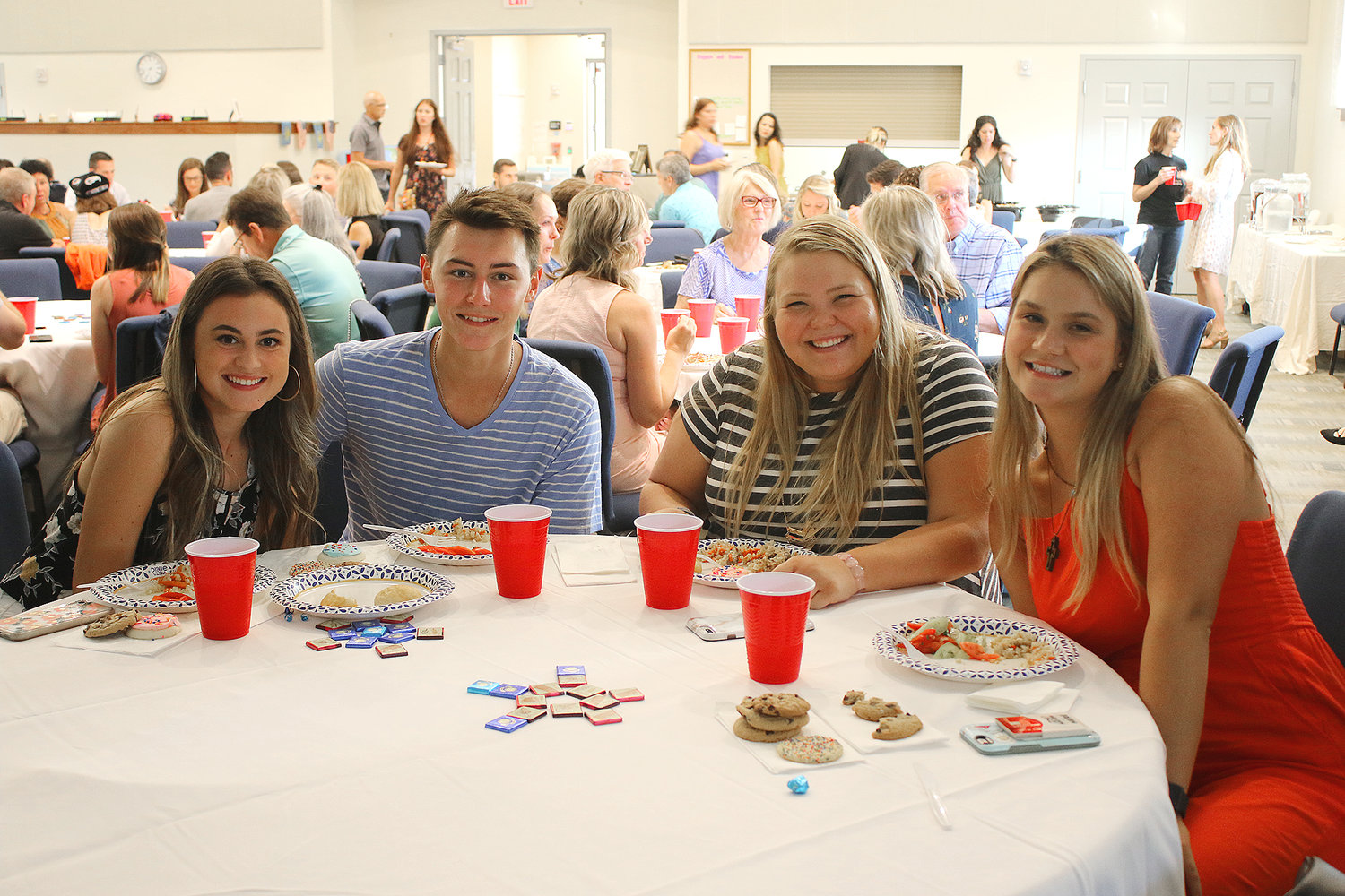 From left, Avery Middleton, Danny White, Katie Mahnken and Sofija Djukiz share a meal of traditional Kazakhstan food prepared by the eight young women who spent the summer working in the United States.